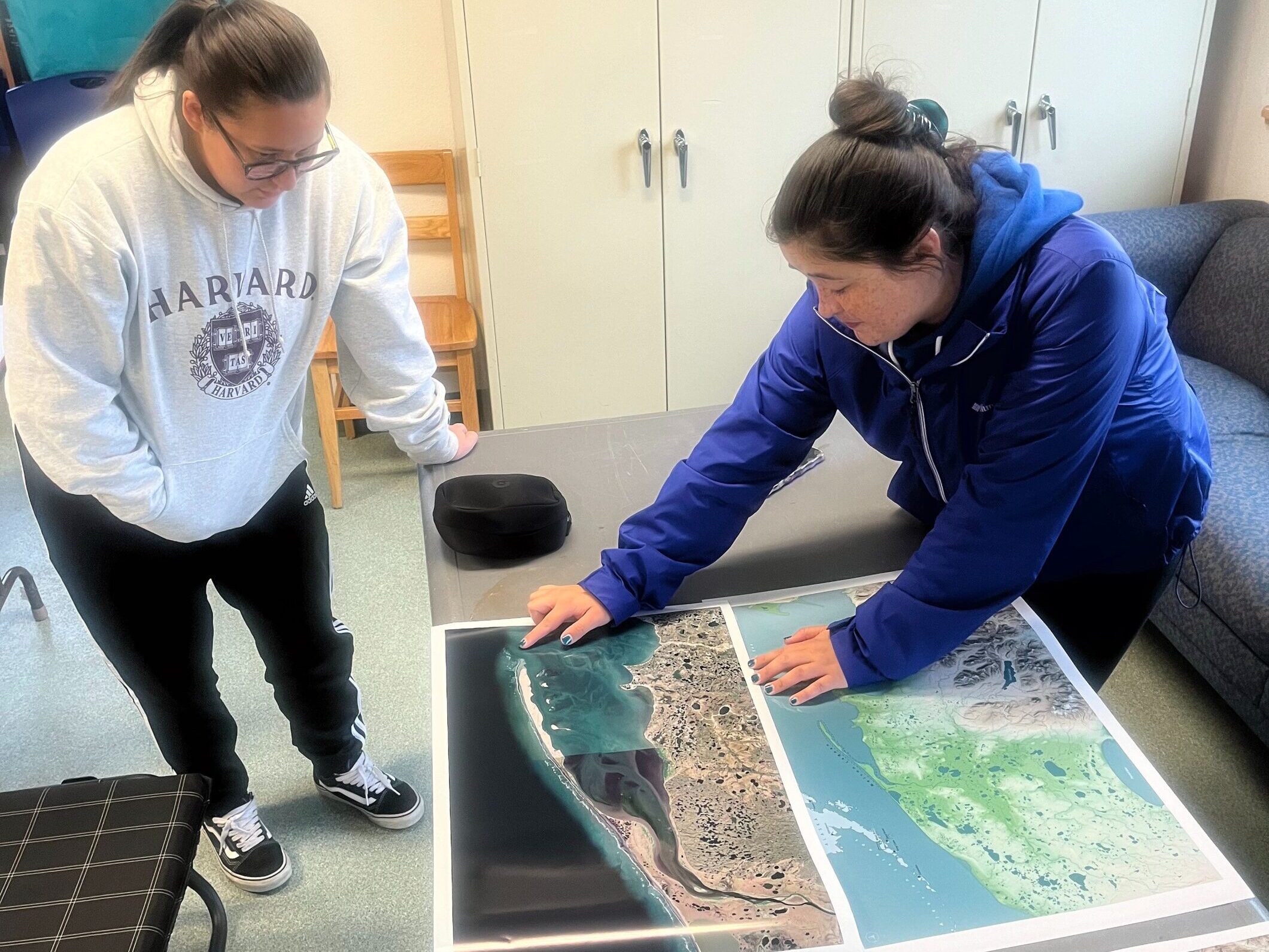 Darcy Peter and Angela Johnson looking at maps of Nelson Lagoon